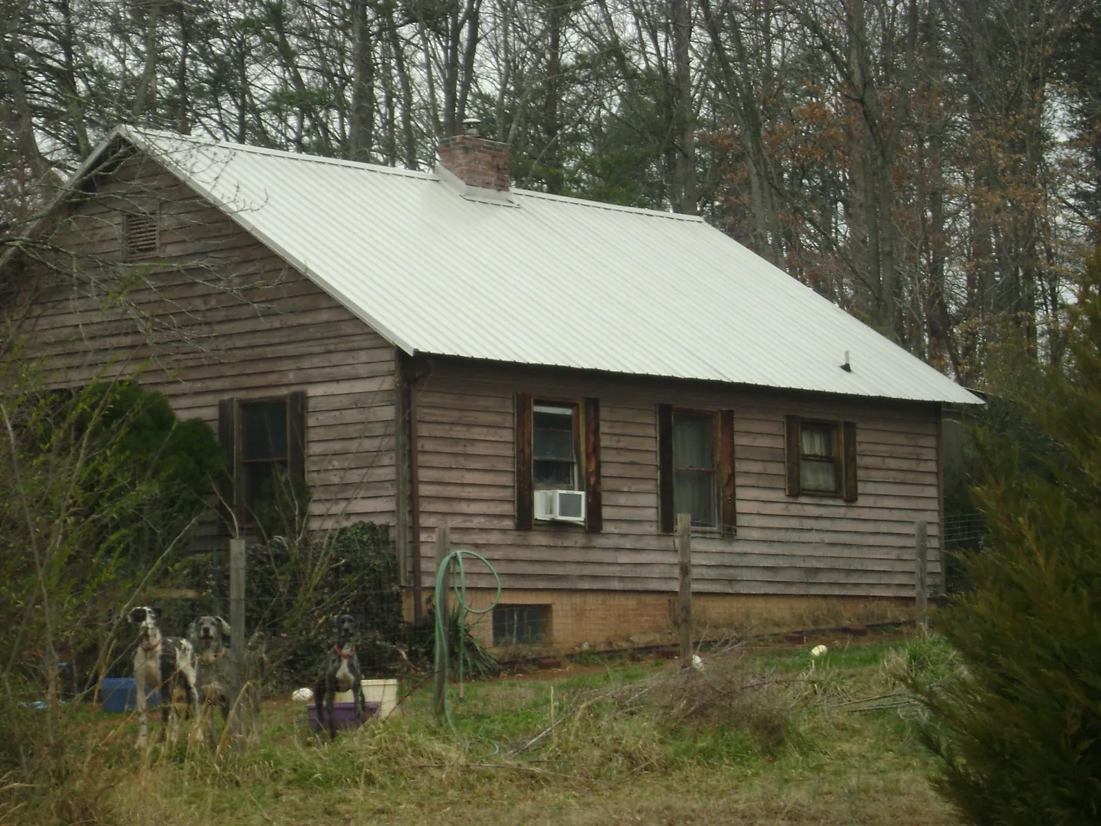 White metal roof on an old wood sided farmhouse, from a Metal Roof Installation job in Morenci